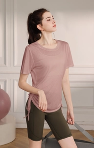 Close-up of pink breathable mesh yoga top with adjustable side drawstrings and green shorts