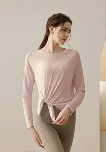 Detail of pink modal yoga top featuring a side knot design and breathable fabric texture