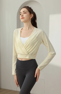Detail of pale yellow wrap-around yoga top with long sleeves and crossover V-neck design