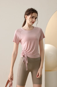 Detail of pink yoga top with adjustable side drawstrings and pleated ruched effect