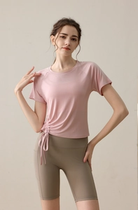 Detail of pink side-cinched drawstring yoga top paired with khaki fitness shorts
