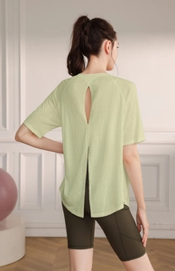 Detail of light green yoga top with teardrop back cutout and split hem for ventilation