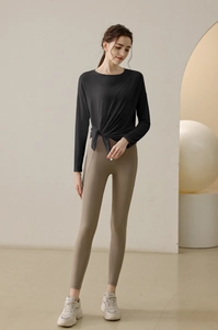 Detail view of the side-slit knot design on the black long-sleeve yoga top
