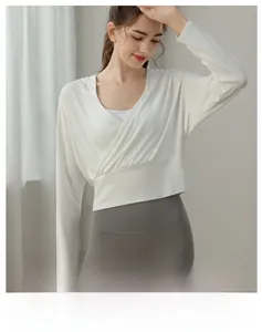 Détail d'un haut de yoga blanc à capuche montrant la maille douce et la coupe croisée