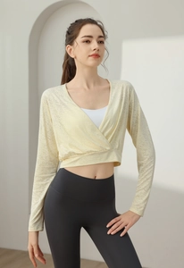 Detail of light yellow jacquard long sleeve yoga top with cross V-neck and breathable mesh fabric