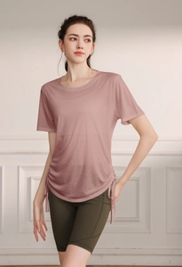 Detail view of pink loose yoga t-shirt with side drawstring and green high waist shorts