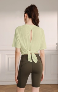Detail of light green yoga top with back teardrop cutout and drawstring hem design