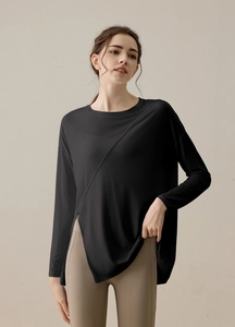 Detail of black modal yoga top featuring asymmetric side slit and diagonal stitching