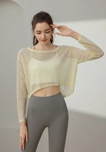 Détail du haut de yoga ample avec protection solaire montrant la texture en maille jaune