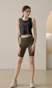 Détail d'un haut court en maille noire respirante et d'un short de yoga vert olive