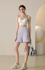 Women in nylon high-waist fitness shorts and V-neck sports bra with a gym bag