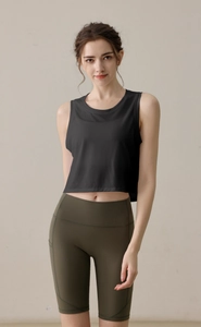Détail du débardeur de yoga en maille dévorée noire avec short de sport vert foncé