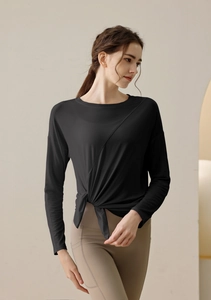 Detail of black modal yoga top featuring a stylish front knot and long sleeve design