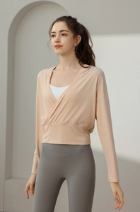 Détail du haut de yoga pêche à col en V porté sur un soutien-gorge de sport blanc