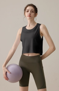 Détail du débardeur de yoga noir texturé associé à un short cycliste taille haute olive