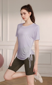 Detail of lavender yoga top with side drawstring design and olive green shorts