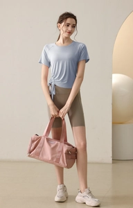 Detail view of light blue yoga top with adjustable drawstring and dark cycling shorts