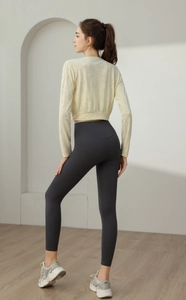 Detail of loose nylon yoga top and high-waisted leggings showing breathable fabric texture