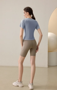Rear view of blue drawstring yoga top and khaki cycling shorts with side pockets
