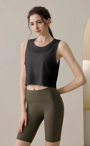 Détail d'un débardeur de sport en maille noire avec un short de yoga vert foncé