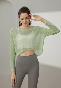 Détail du haut de yoga en maille vert clair montrant la texture respirante et la coupe courte