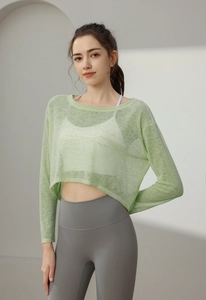Détail d'un haut de yoga en maille vert clair avec brassière blanche et legging gris