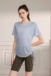 Detail of light blue yoga top featuring adjustable side drawstrings and sheer fabric