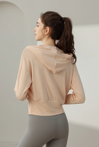 Vue détaillée du sweat à capuche de yoga abricot avec tissu élastique et coupe sportive