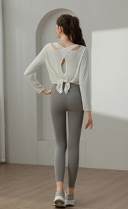 Detail des weißen Langarm-Yogashirts mit offenem Rücken und Bindedetail am Saum