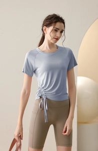 Detail of light blue yoga top with drawstring ruched hem and side pocket yoga shorts
