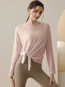 Pink long sleeve yoga top with side knot detail and green leggings with side pockets
