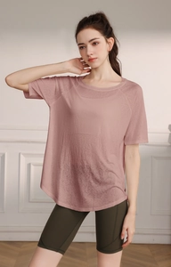 Breathable lotus pink yoga tee and olive green cycling shorts on a model in minimalist studio