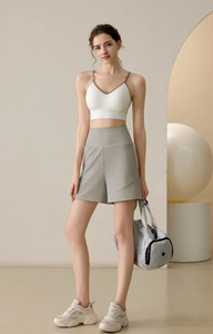 Nylon high-waist sports shorts with v-neck bra outfit shown in a minimalist studio