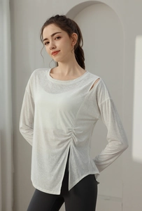 Detail of white jacquard yoga top featuring shoulder cutout and side slit split hem