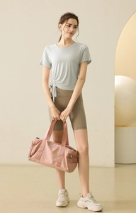 Detail of grey yoga top with side drawstring design and olive green high-waist cycling shorts