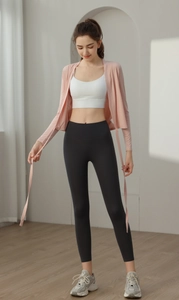 Detail of pink long sleeve yoga cardigan paired with a white sports bra and black leggings