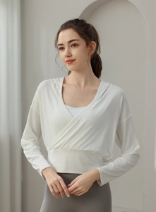 Détail du haut de yoga blanc avec design croisé à l'avant et tissu en maille douce