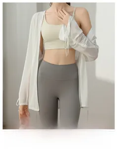 Detailed view of lightweight white yoga cover-up with drawstring cuffs and sheer texture