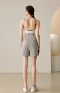 Rear view of loose fit yoga shorts and backless sports bra set in a studio setting