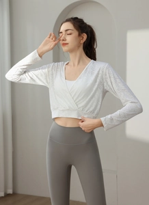 Detail of white jacquard crop top with cross-wrap V-neck and gray high-waist yoga pants