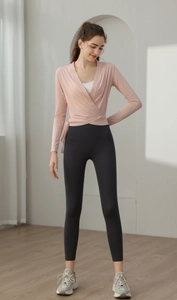 Detail view of pink wrap yoga cardigan with waist tie and high waist black leggings