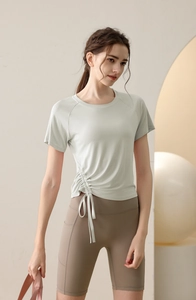 Detail of light green yoga top showing adjustable side drawstrings and ribbed texture