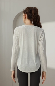 Detail of white jacquard long sleeve yoga shirt showing burn-out texture and hem