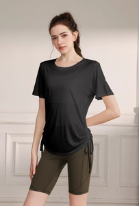 Detail of black yoga top with side drawstring design and olive high waist cycling shorts
