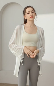 Detail of white loose yoga cover up top with breathable fabric and sleeve tie decoration