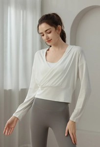 Détail du haut de yoga blanc à capuche croisé et legging gris à taille haute pour sport