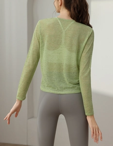 Détail du haut de yoga en maille vert clair montrant le tissu respirant et la coupe