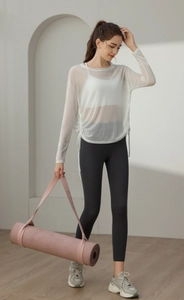 Outdoor side view of white semi-transparent yoga cover-up with adjustable drawstrings