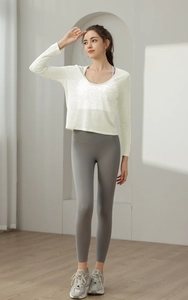 Haut de yoga respirant à manches longues avec legging gris taille haute et baskets sport