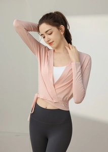 Detail of pink wrap yoga top with side tie design and V-neckline over white vest